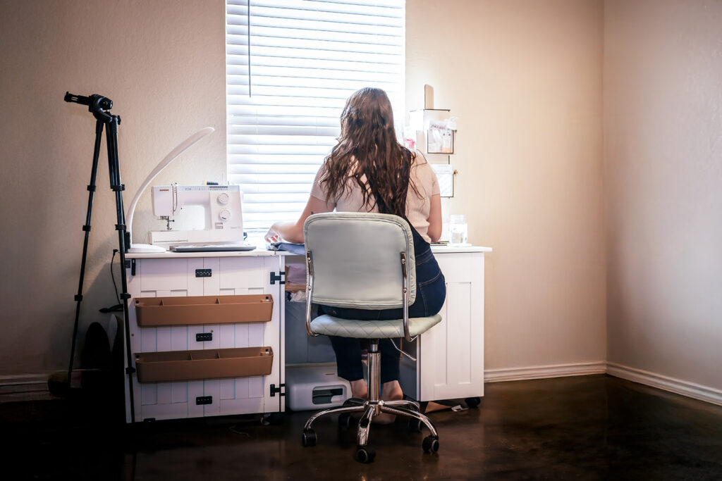New Bruanfels small business owner sitting at desk in home office setting during an in-home brand photography session.