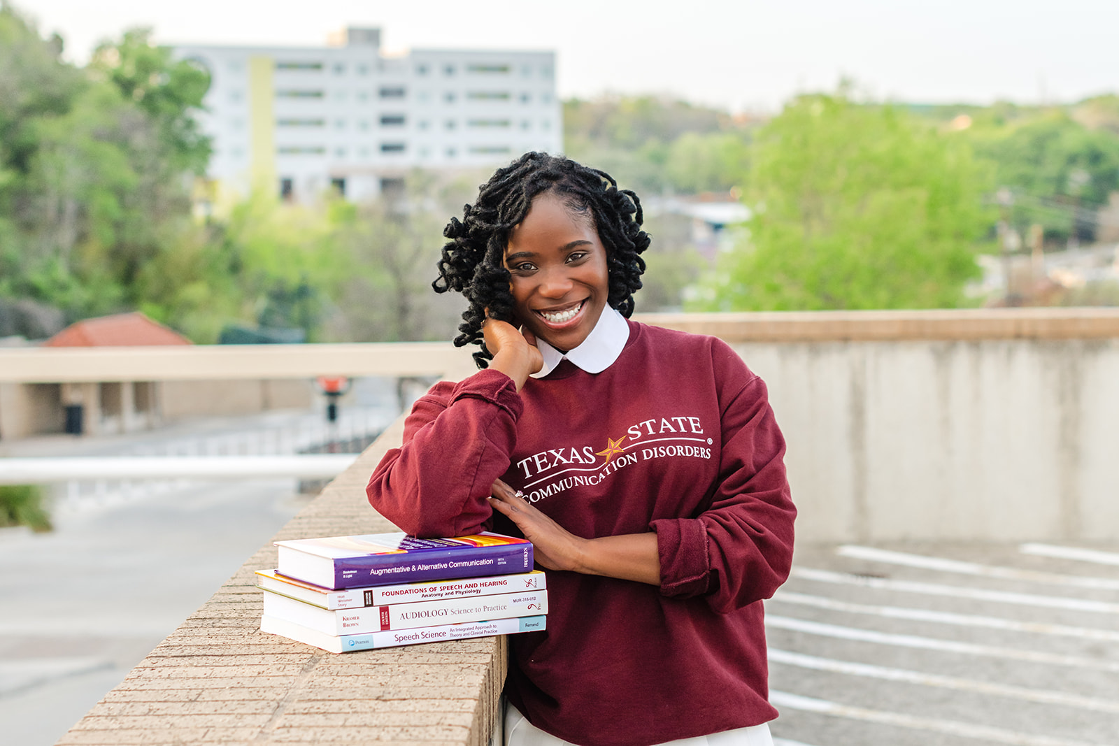 Senior Girl leaning on textbooks at senior session