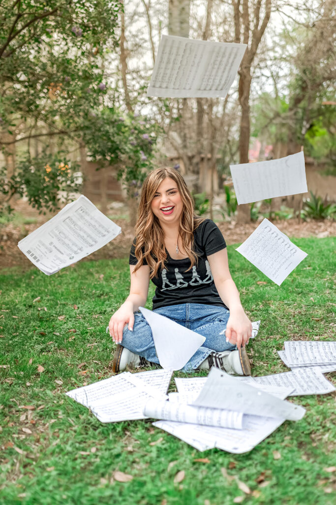 Senior Girl  throwing up sheet music at senior session